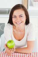 Laughing brunette showing an apple