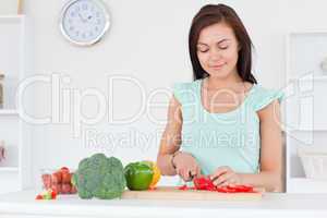 Cute woman slicing a pepper