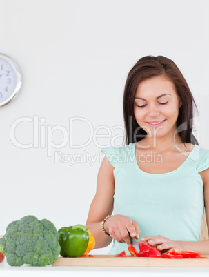 Smiling woman slicing a pepper