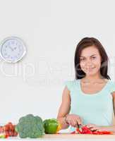 Charming woman slicing a pepper