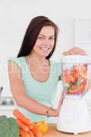 Charming dark haired woman using a blender