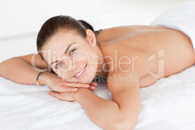 Close up of a woman lying on a massage table looking at the came