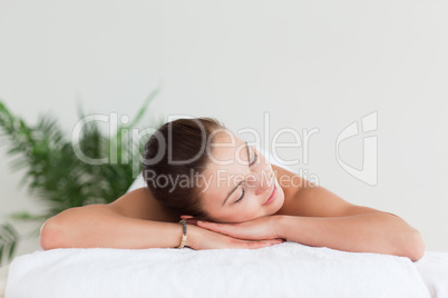 Young brunette lying on a massage table in a spa