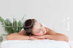 Young brunette lying on a massage table in a spa