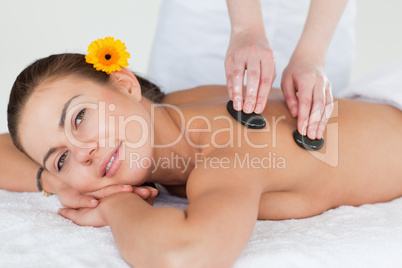 Close up of a cute brunette enjoying a hot stone massage