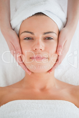 Portrait of a charming brunette having a facial massage