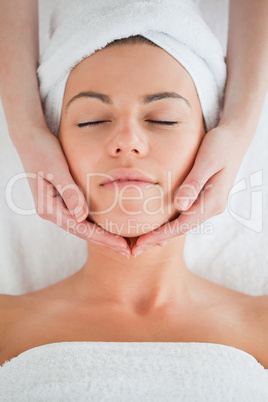 Portrait of a delighted brunette having a facial massage