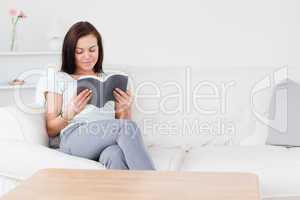 Smiling dark-haired woman reading a book
