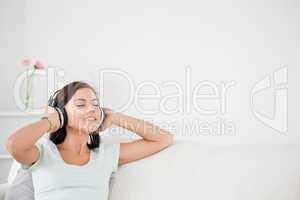 Delighted brunette listening to music