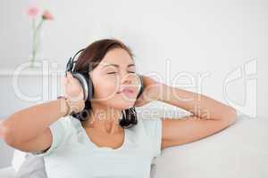 Charming dark-haired woman listening to music