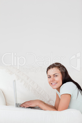 Portrait of a cute woman on a sofa with a laptop