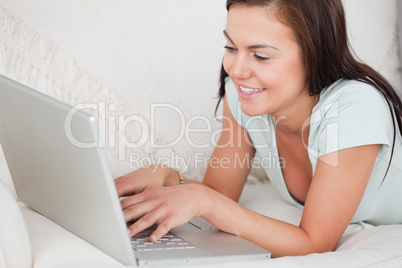 Close up of a young woman on a sofa using a laptop