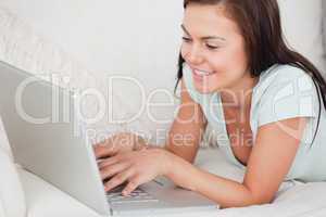 Close up of a young woman on a sofa using a laptop