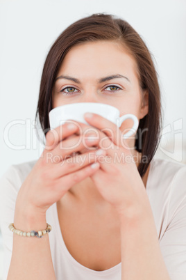 Smiling dark-haired woman having a tea