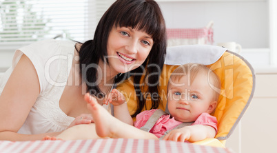 Beautiful brunette woman posing with her baby while sitting