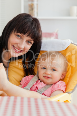 Attractive brunette woman posing with her baby while sitting