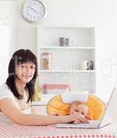 Good looking brunette woman relaxing with her laptop next to her