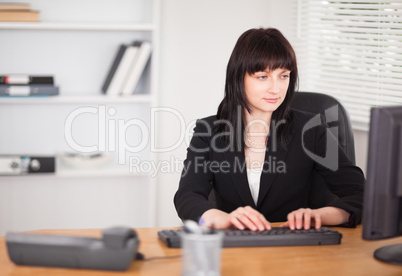 Beautiful brunette woman working on a computer while sitting at