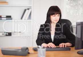 Beautiful brunette woman working on a computer while sitting at