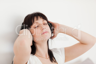 Charming brunette woman relaxing with headphones while sitting o