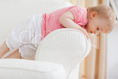 Cute blond baby standing on a sofa