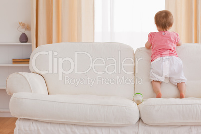 Blond baby standing on a sofa