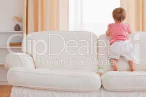 Blond baby standing on a sofa