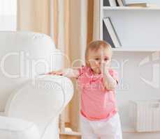 Baby standing near a sofa