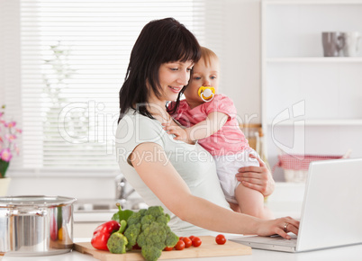 Good looking woman holding her baby in her arms