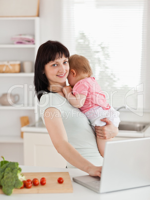 Good looking brunette woman holding her baby in her arms