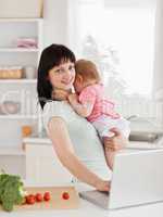 Good looking brunette woman holding her baby in her arms