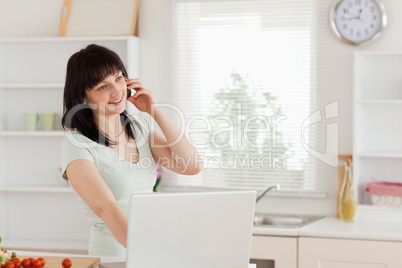 Charming brunette woman on the phone while relaxing with her lap