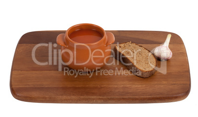 Soup in clay pot on wooden kitchen board