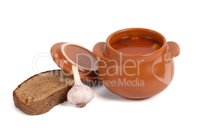 Borsch in clay pot with bread and garlic