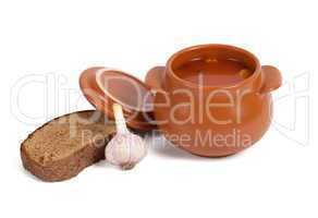 Borsch in clay pot with bread and garlic