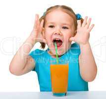 Little girl drinks orange juice