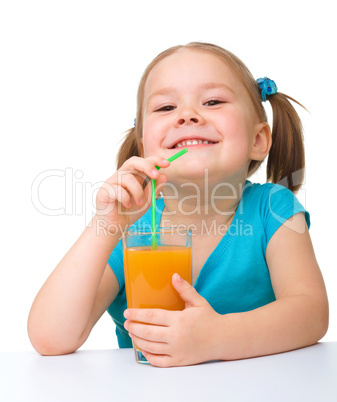 Little girl drinks orange juice