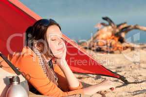 Camping woman relax in tent by campfire