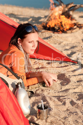 Camping happy woman relax in tent by campfire