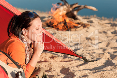 Camping happy woman relax in tent by campfire