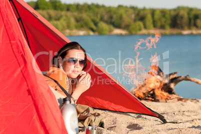 Camping happy woman relax in tent by campfire