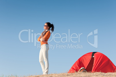 Camping happy woman outside tent on beach