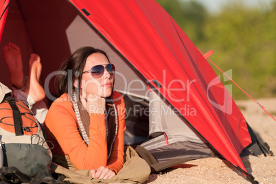 Camping happy woman in tent on beach sunset