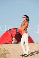 Camping happy woman outside tent on beach