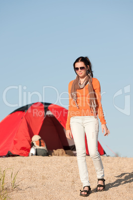 Camping happy woman outside tent on beach