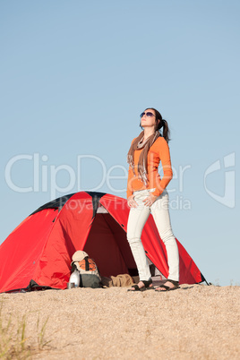 Camping happy woman outside tent on beach