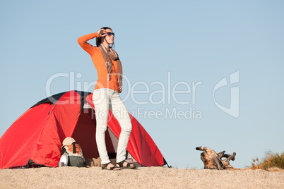 Camping happy woman outside tent on beach