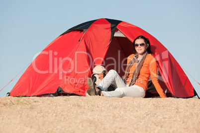 Camping happy woman sitting front of tent