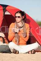 Camping happy woman sitting front of tent