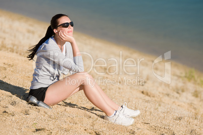 Summer sport fit woman sitting on beach